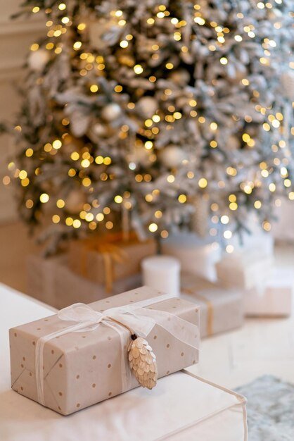 gift-box-wrapped-wrapping-paper-with-pine-cone-background-new-year-lights-bokeh-christmas-tree-copy-space-soft-selective-focus_182920-2251