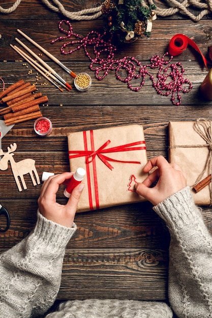 woman-decorating-box-with-christmas-gifts_266247-953 (1)